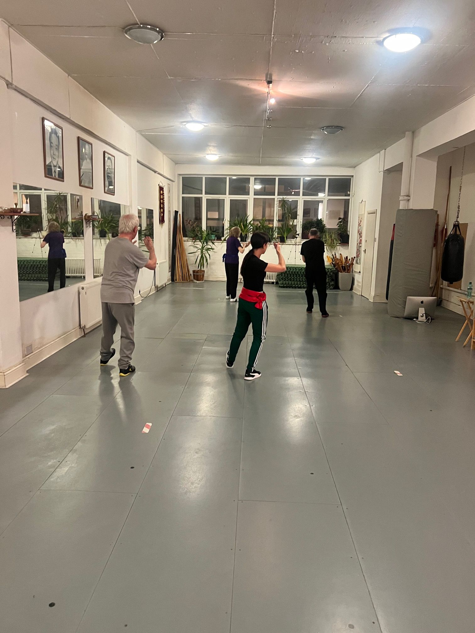 a group of people practicing martial arts in an empty room